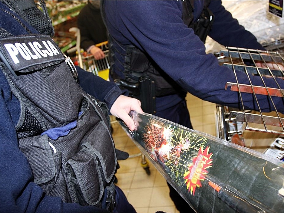 Zbliżenie na fajerwerki, które trzyma policjant