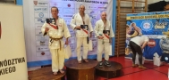 trzech judoków stojących na podium