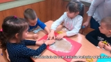 Na zdjęciu dzieci wykrawają pierniczki z rozwałkowanego ciasta.