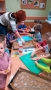 Na zdjęciu dzieci układaja na blaszki z papierem do pieczenia wykrojone pierniczki.