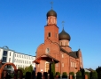 zdjęcie przedstawia budynek cerkwi zbudowanej z czerwonej cegły, posiada dwie kopuły