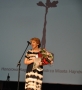 wypowiedź laureatki do mikrofonu, w rękach trzyma bukiet kwiatów
