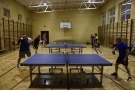 Mecz Hajnówka - Lombard Bielsk Podlaski, mężczyźni grają w tenisa stołowego przy trzech stołach.