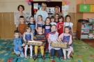 Zdjęcie grupowe dzieci i pań nauczycielek, dzieci trzymają blachy z ciasteczkami.