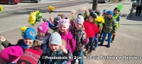 Dzieci podczas spaceru, trzymają żółte kwiaty.