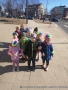 Dzieci z kolorowymi opaskami na głowach spacerują po mieście.