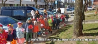 Dzieci stoją na chodniku w centrum miasta.