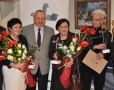 Laureaci z dyplomami i kwiatami w dłoniach pozują do zdjęcia