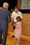 Mała dziewczynka w różowej sukience z tatą odbiera od Burmistrza medal.