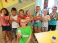 Dzieci trzymają wypełnione kolorową solą buteleczki