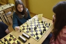 Dwie dziewczynki siedzą przy szachownicy.
