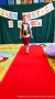 Dziewczynka na czerwonym dywanie robi pokaz stroju