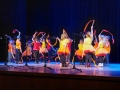 Zdjęcie przedstawia tańczące dzieci z kolorowymi wstążkami na scenie Hajnowskiego Domu Kultury