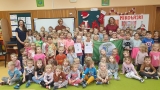 Zdjęcie grupowe dzieci i opiekunów, którzy trzymają Zielona flagę.