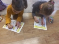 Dzieci kolorują obrazki, siedząc na podłodze.