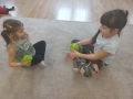 Dziewczynki bawią się na sywanie pluszowymi kostkami do gry.