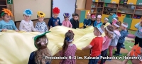 dzieci trzymają żółtą chustę