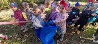 Dzieci wrzucają do worka śmieci
