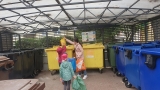 Dzieci wrzucają do kosza śmieci