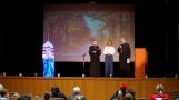 kobieta i dwóch duchownych stoją na scenie