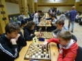 chłopcy podczas siedzą przy stołach, na ktrych leża szachy