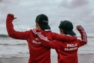Chłopcy w czerwonych bluzach z napisem PASJA HAJNÓWKA. W tle widać morze