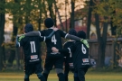trzech chłopaków  w czarnych strojach piłkarskich