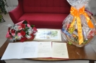 listy gratulacyjne, obraz, bukiet kwiatów i kosz pełen słodyczy