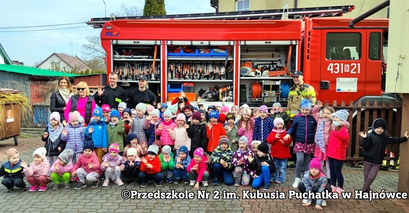 duża grupa przedszkolaków pozuje do zdjecia przed wozem strażackim