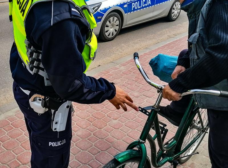 policjantka stoi przy rowerzyście. W tle widać radiowóz.