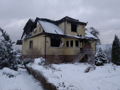 Zdjęcie przedstawia spalony dom.