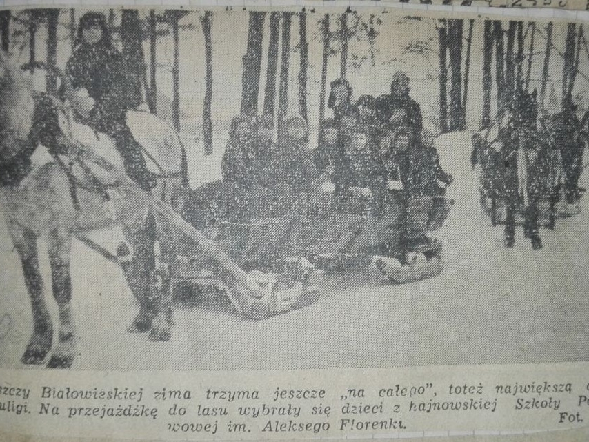 Fotografia zdjęcia wyciętego ze starej gazety. Na zdjęciu dwa konie z saniami, na nich ludzie. Pod zdjęciem podpis.