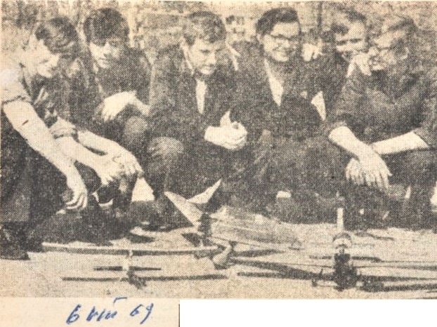 zdjęcie po lewej obok tekstu: skan czarno-białego zdjęcia prasowego; czterech chłopców pracuje nad modelem swojego kolejnego projektu, trzymają w rękach coś, co przypomina szkielet skrzydeł maszyny latającej