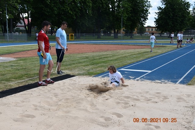Zawodnicy wykonują skok w dal