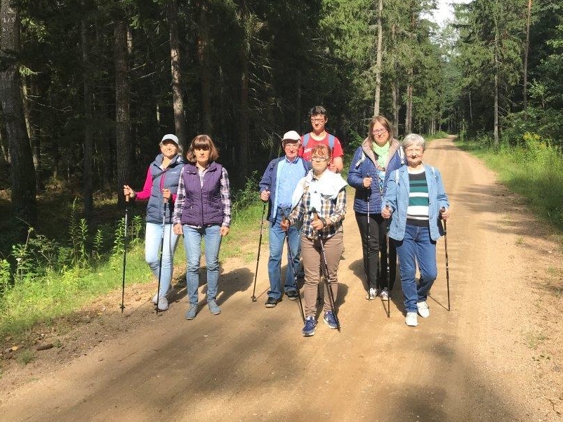 Grupa ludzi idących przez las