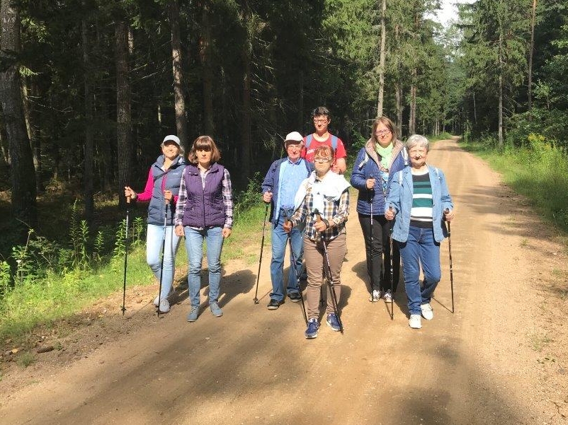 Grupa ludzi idących przez las