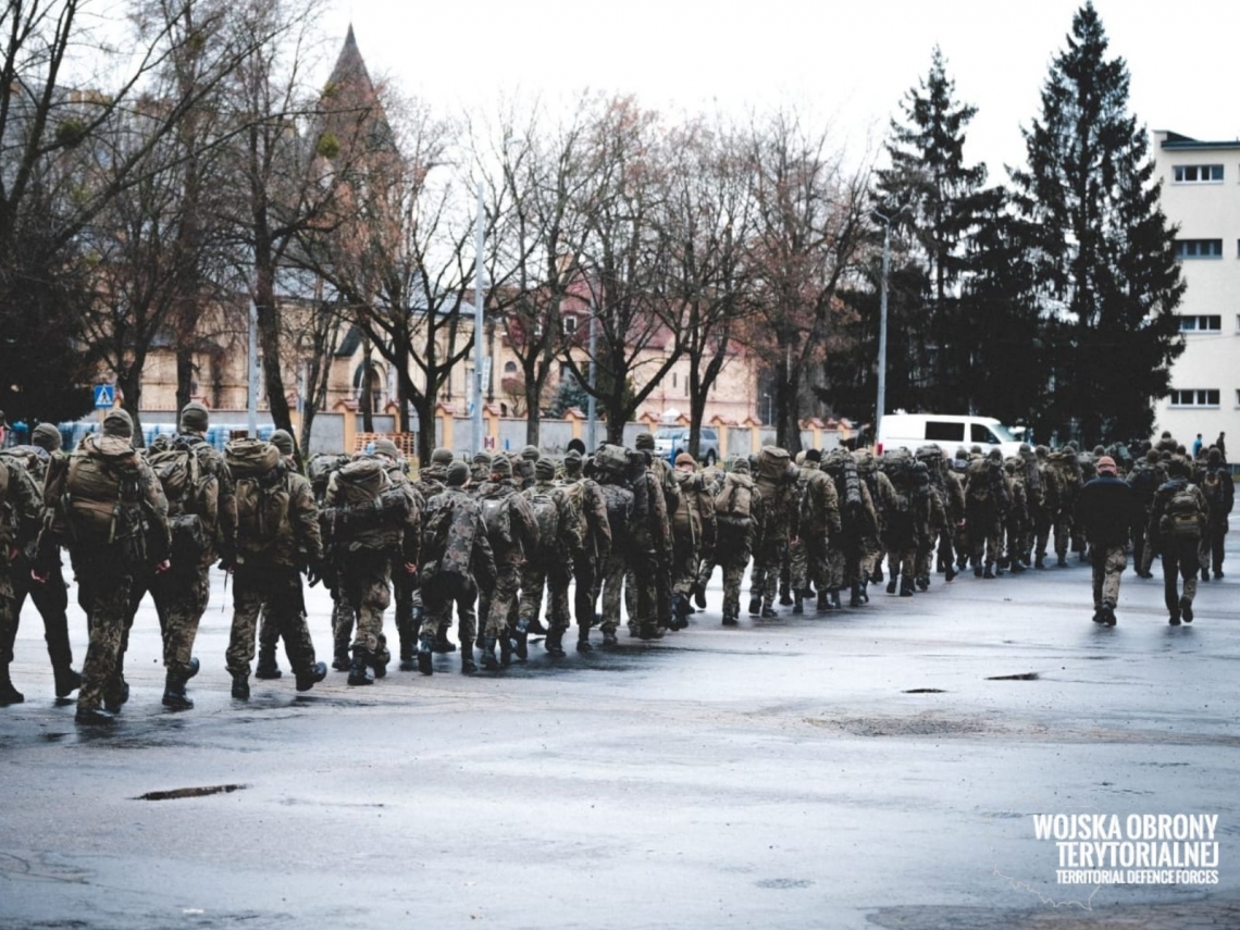 ggrupa umundurowancyh osób idzie w jednym kierunku