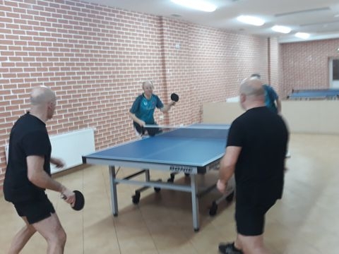 Mecz Łosice - Top Spin Siemiatycze, czterech mężczyzn ubranych w stroje sportowe gra w tenisa stołowego.