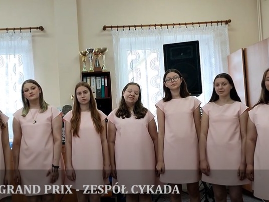 Osiem dziewcząt w różowych sukienkach pozuje do zdjęcia.