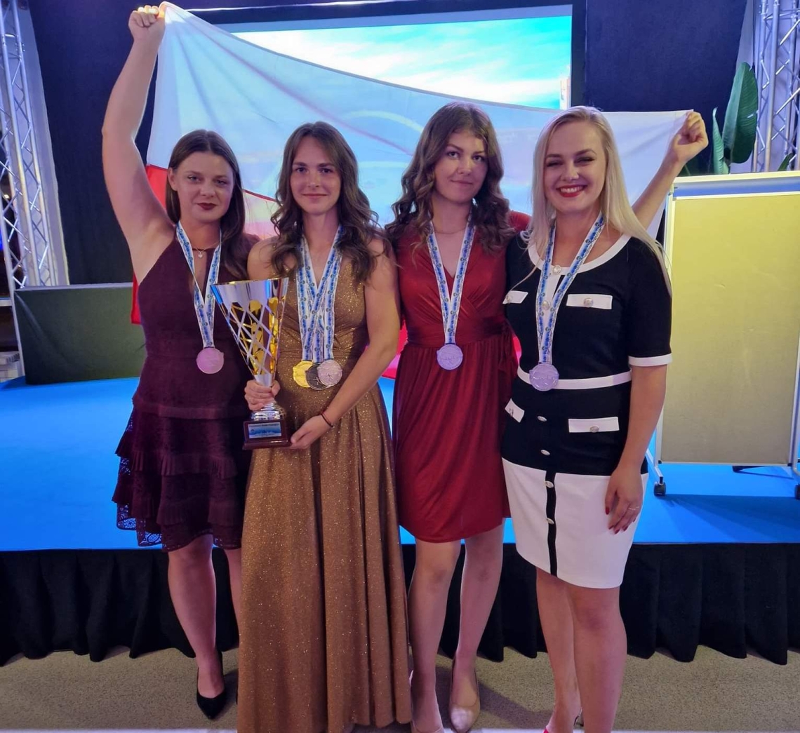 cztery dziewczyny, wśród nich zdobywczyni mistrzostwa trzymająca w ręku puchar
