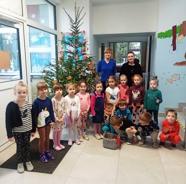 Dzieci stoją przy choince