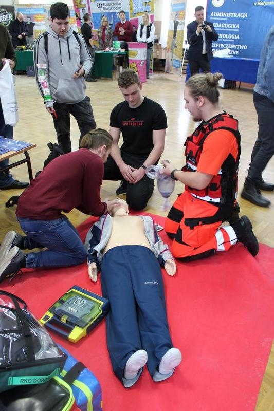Uczniowie biorą udział w prezentacji pomocy społecznej z udziałem manekina