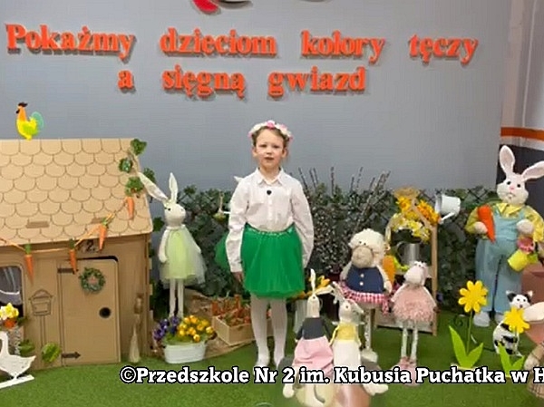 dziewczynka stoi w otoczeniu makiet domu i figur zwiazanych z wiosną
