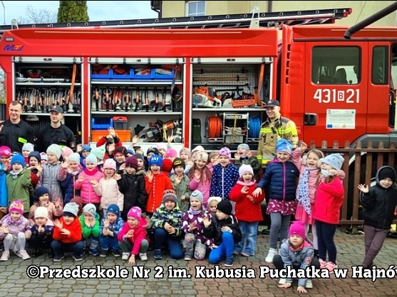 duża grupa przedszkolaków pozuje do zdjecia przed wozem strażackim