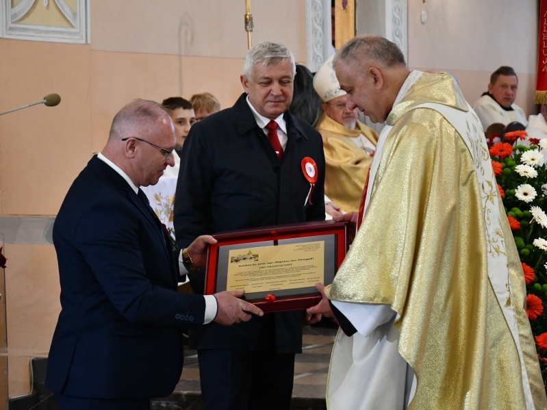 Burmistrz Miasta wraz ze Starostą wręczają jubileuszowy grawetrton proboszczowi