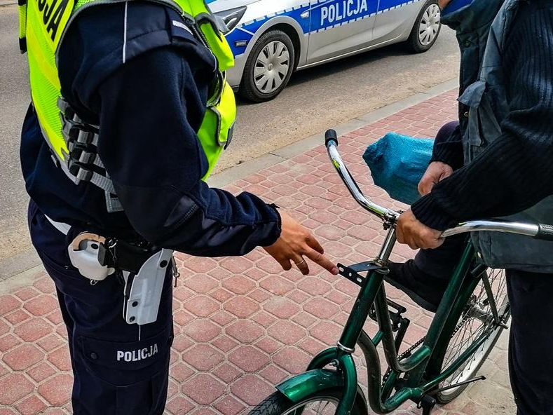 policjantka stoi przy rowerzyście. W tle widać radiowóz.