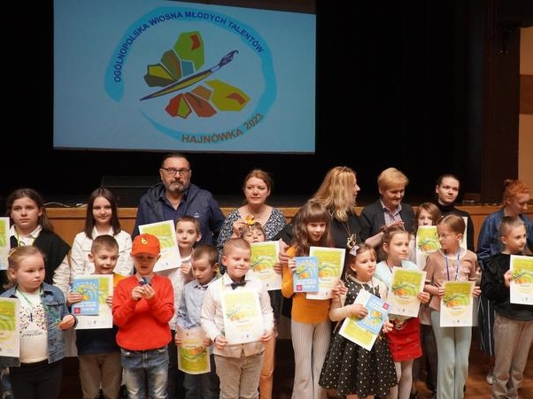 grupa nagrodzonych dzieci oraz członkowie komisji pozują do zdjęcia