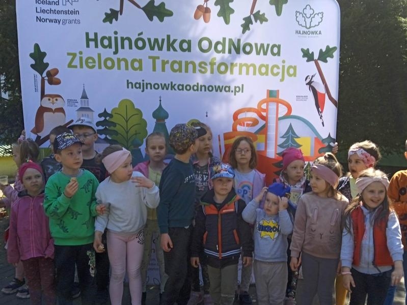 grupa dzieci pozuje do zdjecia przez banerem reklamującym akcję