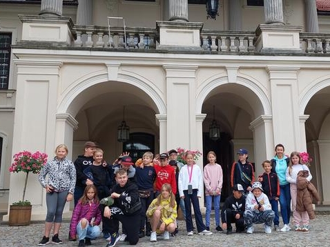 Młodzież poozuje do zdjęcia przed wejściem do budynku