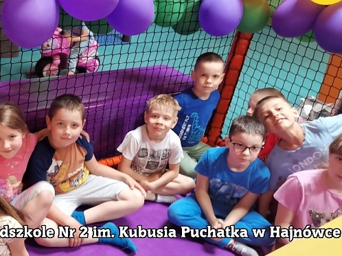 uśmiechnięte dzieci siedzą na materacach